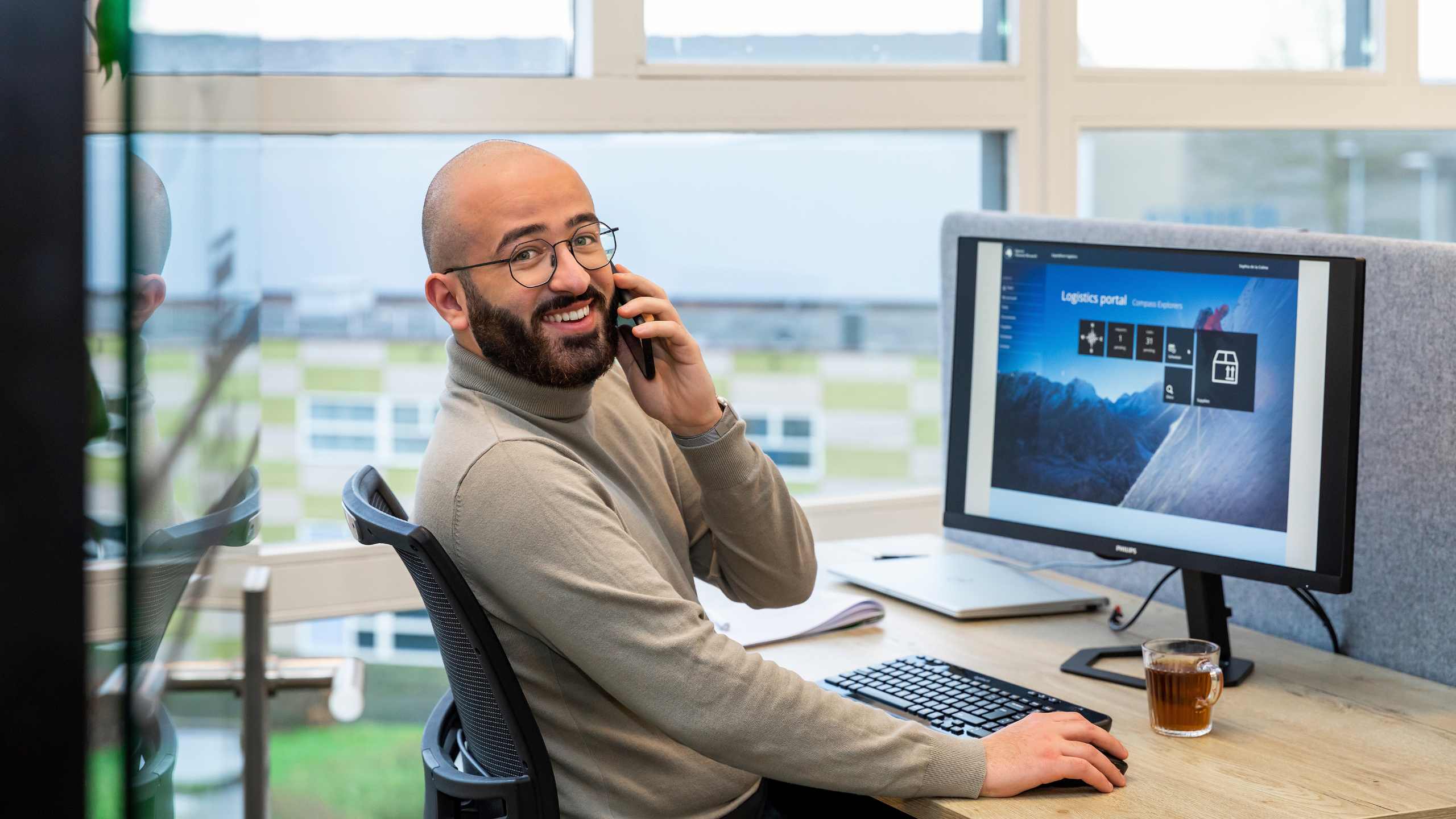 Collega aan het bellen met Quercis business portal op scherm