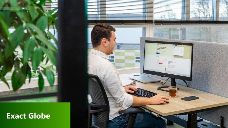 Collega achter computer met Exact op de pc