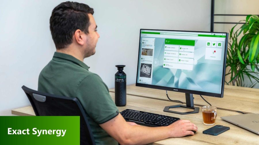 Collega achter computer met Exact synergy op de pc