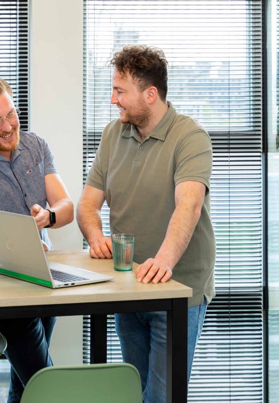 Collega's in overleg achter laptop